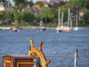 Nautical steering wheel of a ship with a view of the water and the coast, Eckernförde,