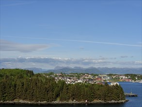 City view with a wooded island section, houses in the foreground and Bergen in the background,