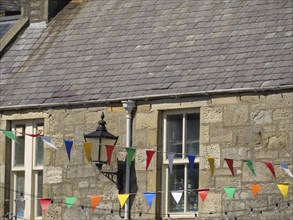 Stone building with grey roof and colourful pennants in the sunshine, Lerwick, Shetlands, Scotland,