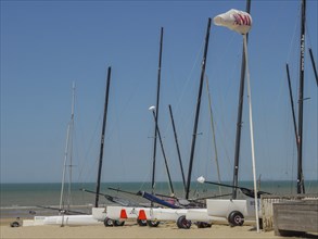 Several sailing boats on the beach, the sea and a clear blue sky in the background, de haan,