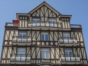 Facade of a multi-storey half-timbered house with balconies on a sunny day, de haan, belgium