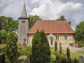 Quiet church with red tiled roof and surrounded by well-tended bushes and trees, Arnis,