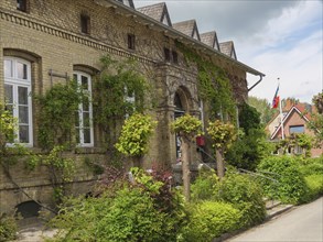 Historic building with ivy-covered facades, windows and cloudy sky, Arnis, Schleswig-Holstein,