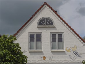 The façade of a house with ornate windows and drawings on the gable wall, Arnis,