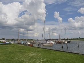 Tranquillity at the harbour where sailboats bob in the water under a cloudy sky, Arnis,