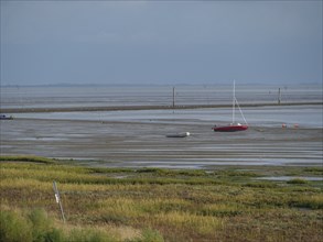 Wide mudflats with boats in the shallow water and a calm, peaceful feeling, juist, east frisia,