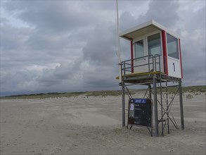 An observation tower on an empty beach under a cloudy sky, juist, east frisia, germany