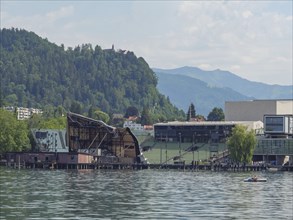 View of the lake stage in Bregenz with green hills and mountains in the background, Lindau, Lake