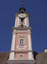 A baroque tower with a clock and pink-coloured façade against a clear blue sky, Meersburg, Germany,