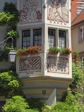 A decorated half-timbered house with murals and red geraniums in full bloom, Meersburg, Germany,