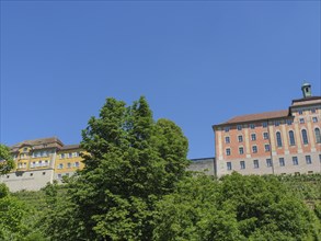 Castle buildings towering over green trees under a clear blue sky, Meersburg, Germany, Europe