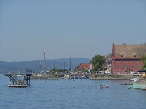 Harbour view with boats and classic buildings on the shore of a lake under a clear summer sky,