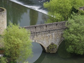 An old stone bridge crossing a river, surrounded by lush trees, Luxembourg City, Luxembourg, Europe