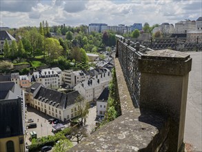 A viewpoint with railings offers a wide view of the city and the surrounding buildings and trees,