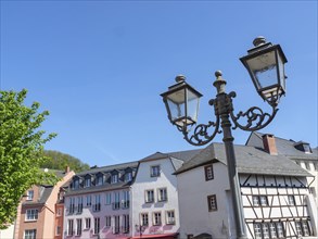 View of a historic street with half-timbered houses and a street lamp under a clear blue sky,