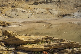 A small pond surrounded by rocks and barren landscape in the highlands, graubünden, switzerland