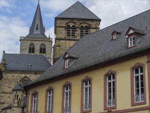 Photo of a historic church with pointed roofs and gothic style under a cloudy sky, trier, germany