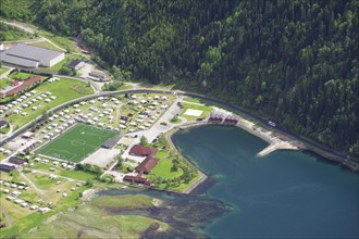 Top view of a campsite with football pitch and neighbouring lake in the middle of a forest, view