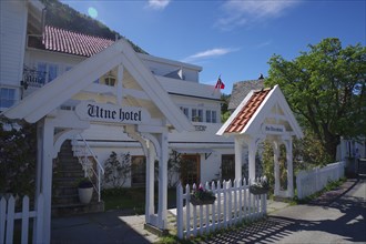 Historic wooden hotel with white facades, red roofs, flowers and blue sky, Edvard Grieg, Utne,