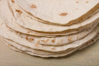 A stack of Mexican tortillas, on a gray table, top view, close-up, no people