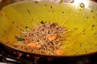 Close up of banh xeo or vietnamese crepe being cooked in a wok, authentic traditional Vietnamese