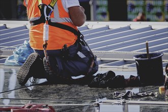 A construction worker on a roof, taken in Berlin, 07/08/2024