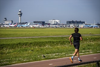 Joggers in front of the airport, aeroplanes at Amsterdam Airport Schiphol, taxiway, apron, air