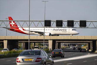 Amsterdam Schiphol Airport, Helvetic Airways Embraer ERJ-195, aircraft on the taxiway, bridge over