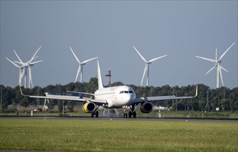 Vueling.com aircraft landing at Amsterdam Schiphol Airport, Polderbaan, 18R/36L, wind farm in the