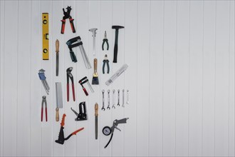 Tools on the wall, file, rasp, stapler, blind rivet pliers, spirit level, hammer, metre rule,