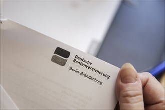 An elderly woman opens a letter from Deutsche Rentenversicherung. Berlin, 05.08.2024