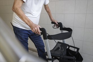 An elderly man walks with a rollator through a hallway in Berlin, 05/08/2024