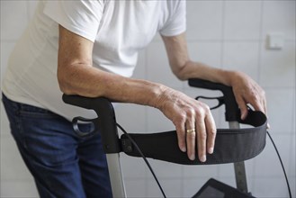 An elderly man walks with a rollator through a hallway in Berlin, 05/08/2024