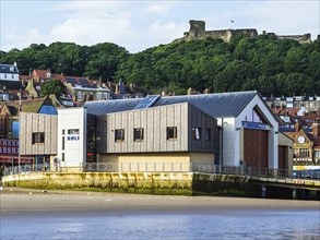 RNLI Scarborough Lifeboat Station and boat over Scarborough Beach, Scarborough, North Yorkshire,