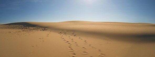 Sand dunes with blue sky and sun