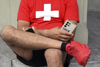 Man with mobile phones and Swiss cross