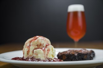 Close-up of delicious chocolade brownie dessert with cream ice cream and raspberry beer