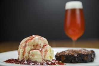 Close-up of delicious chocolade brownie dessert with cream ice cream and raspberry beer