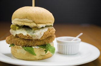 Close-up of homemade tasty chicken burger on wooden table and black background