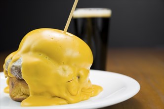 Delicious close-up of hamburger covered in cheddar cheese sauce