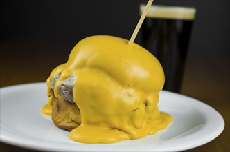 Delicious close-up of hamburger covered in cheddar cheese sauce