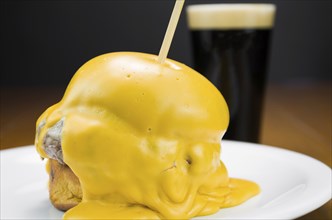 Delicious close-up of hamburger covered in cheddar cheese sauce