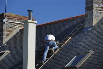 Roofer working next to the chimney editorial