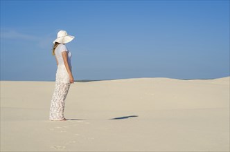 Young woman walking in the dunes, desert