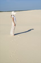 Young woman walking in the dunes, desert