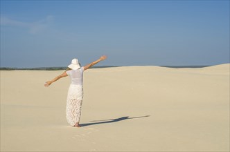 Young woman walking in the dunes, desert