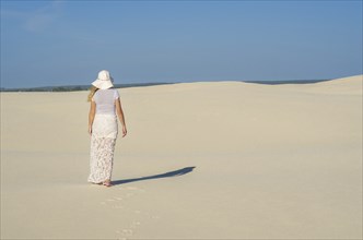 Young woman walking in the dunes, desert