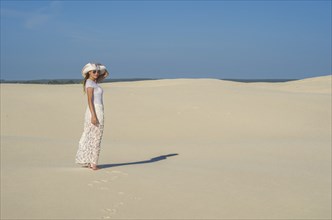 Young woman walking in the dunes, desert