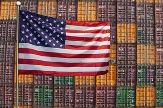 Symbolic image of the US economy: USA flag in front of a large stack of shipping containers