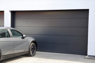 Modern garage door (sectional door) with car parked in front of it